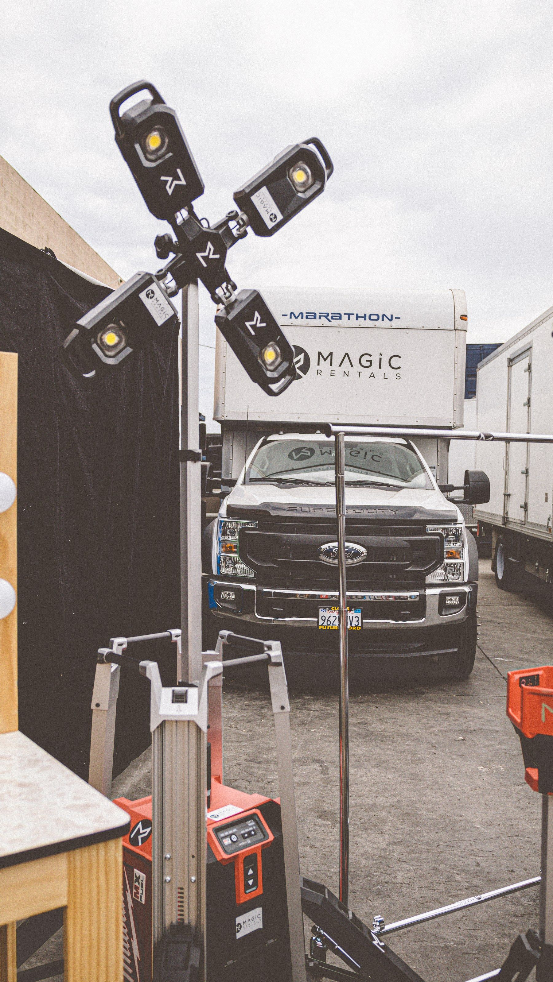 Battery light tower beside a Magic Rentals truck